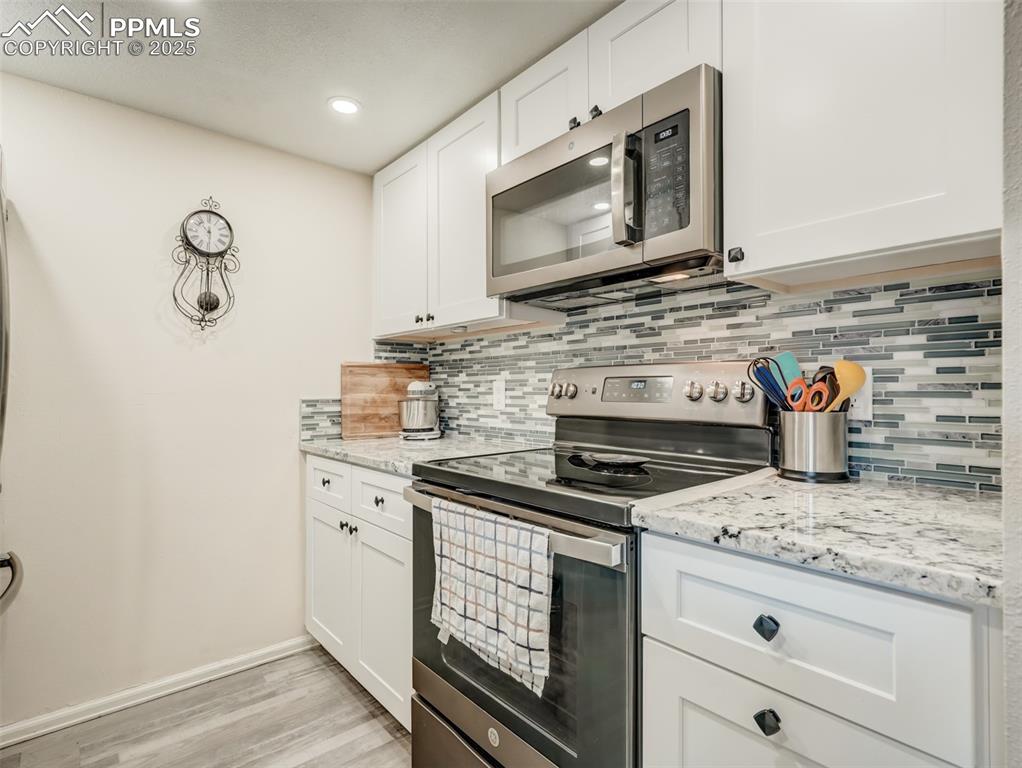 842 Tenderfoot Hill Road, Unit 1 Colorado Springs, CO 80906 - Photo 20 of 41 a kitchen with stainless steel appliances granite countertop a stove microwave and cabinets