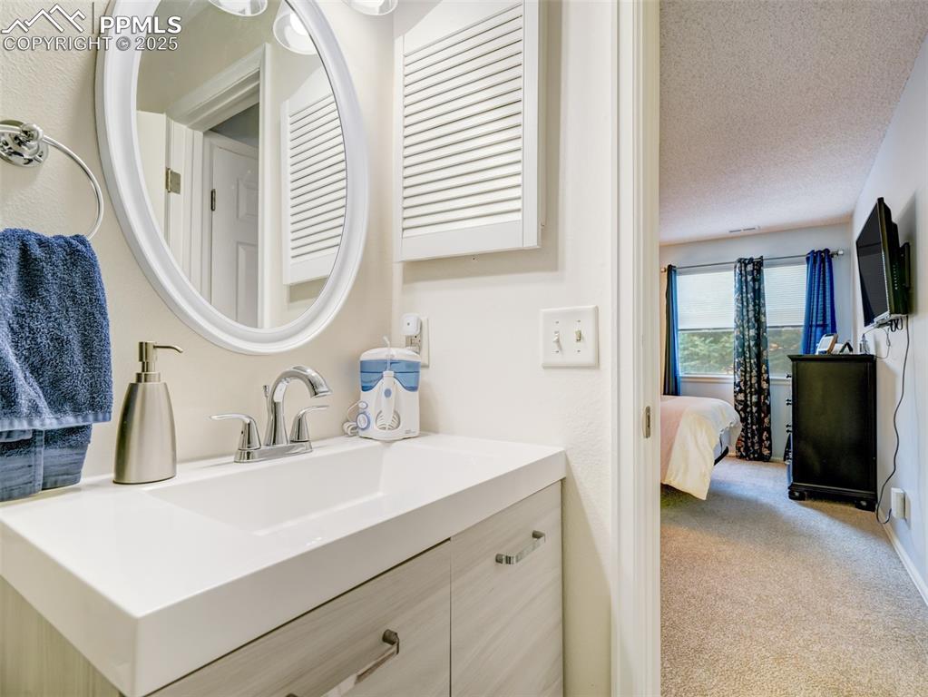842 Tenderfoot Hill Road, Unit 1 Colorado Springs, CO 80906 - Photo 34 of 41 a en suite bathroom with a double vanity sink and a mirror