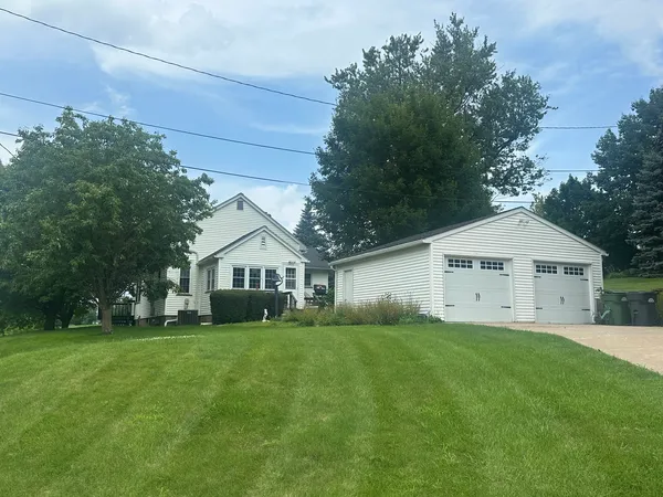 a view of a yard in front of a house with large trees