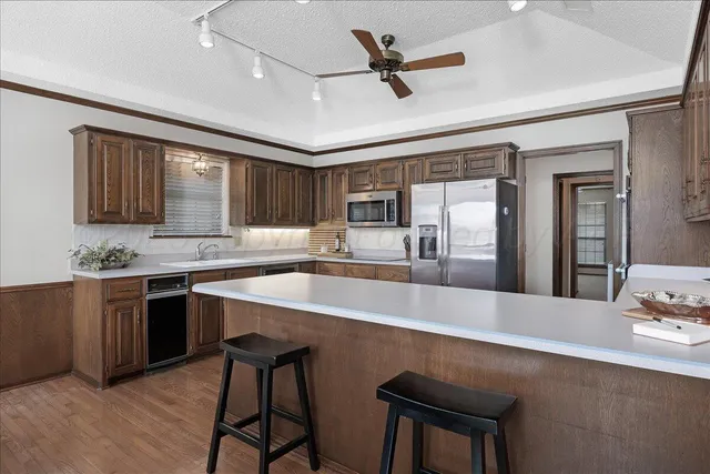 a large kitchen with kitchen island a stove a sink a dining table and chairs