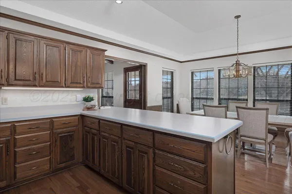 a kitchen with a sink cabinets and wooden floor