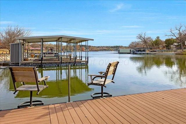 a view of a swimming pool with chairs and wooden floor