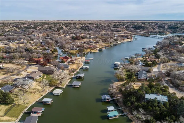 an aerial view of ocean and residential houses with outdoor space