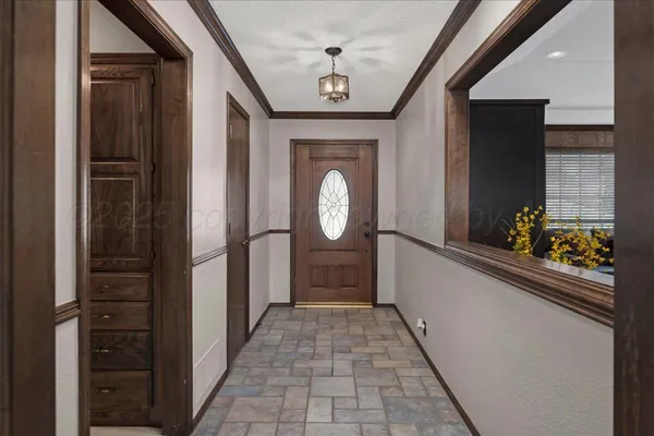 a hallway with painting and a large mirror
