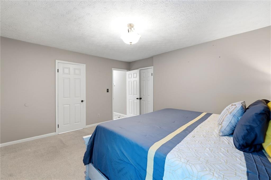 3121 Bonds Lake Road Northwest Conyers, GA 30012 - Photo 17 of 36 a bedroom with a bed and a chandelier