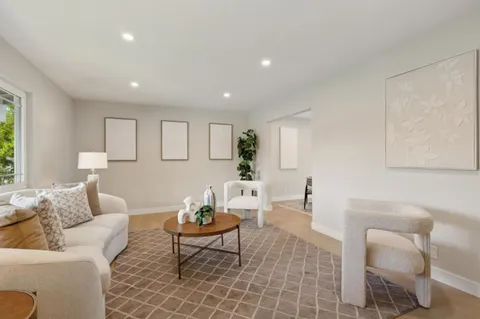 a living room with furniture a rug and a table