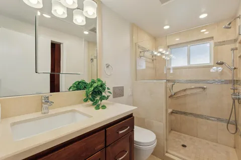 a bathroom with a sink a toilet and shower