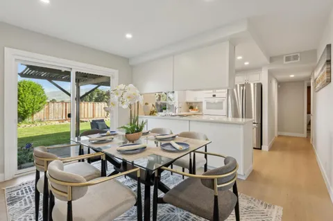 a dining room with furniture and a floor to ceiling window