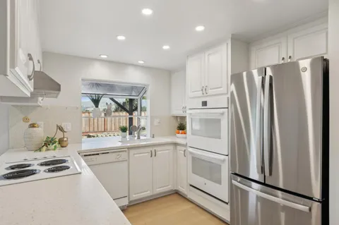 a kitchen with white cabinets and white appliances