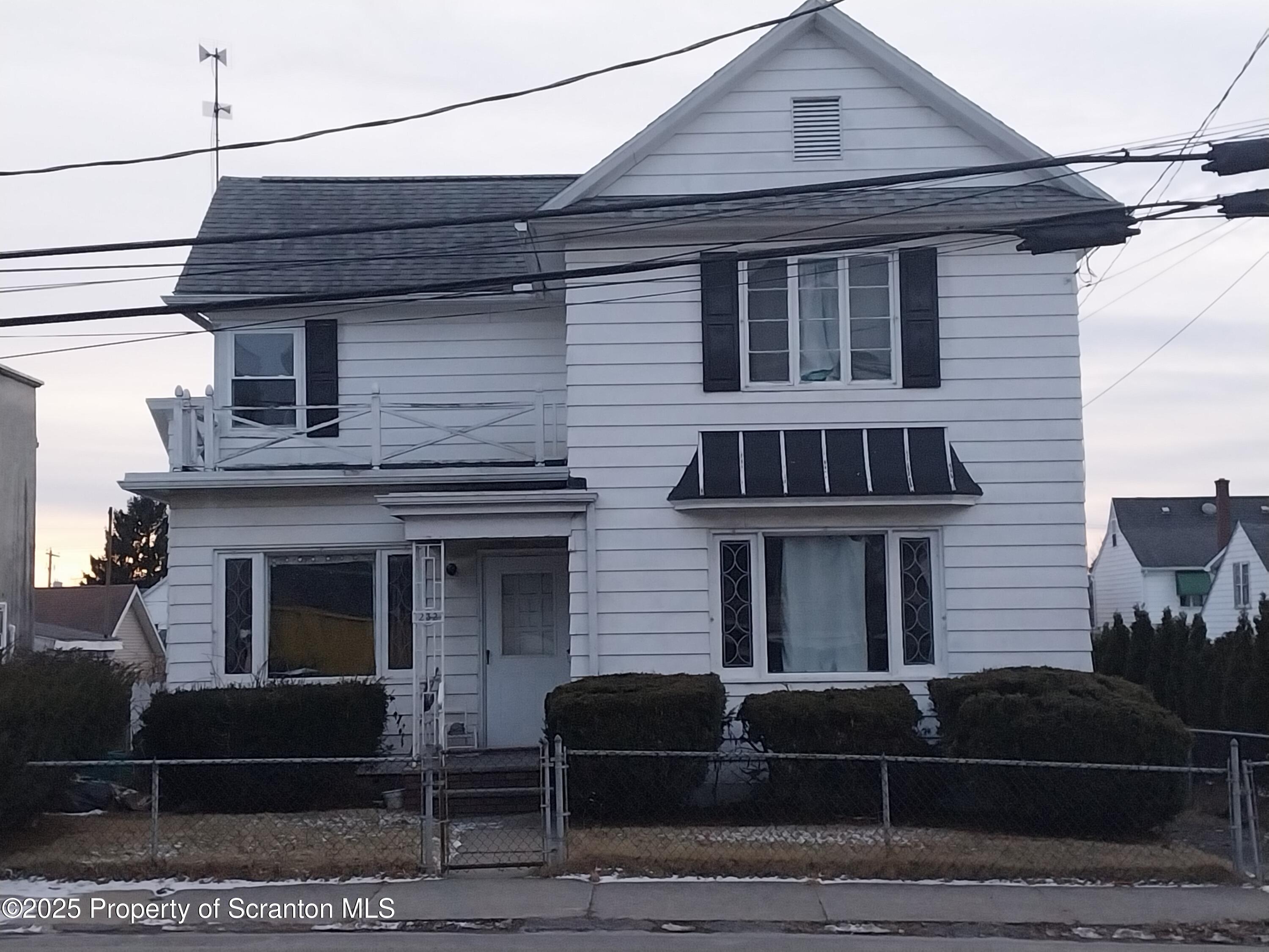 a front view of a house with plants