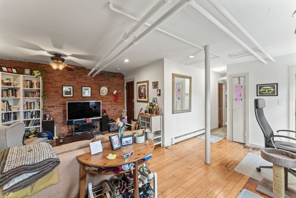 388 Arborway Boston, MA 02130 - Photo 20 of 29 a living room with furniture a flat screen tv and a floor to ceiling window