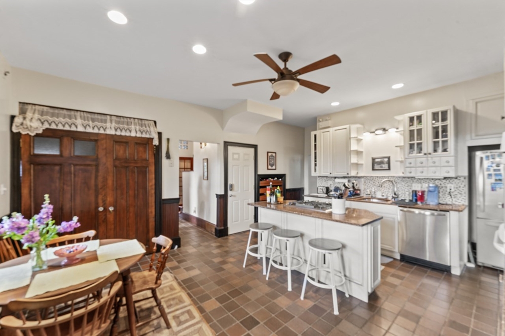 388 Arborway Boston, MA 02130 - Photo 6 of 29 a kitchen with a dining table chairs stove and white cabinets