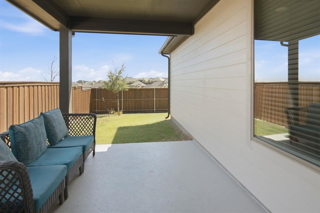 201 Pintail Lane Rhome, TX 76078 - Photo 28 of 36 Covered concrete patio with a painted concrete surface, offering direct access to a fenced backyard featuring a manicured lawn and mature privacy fencing