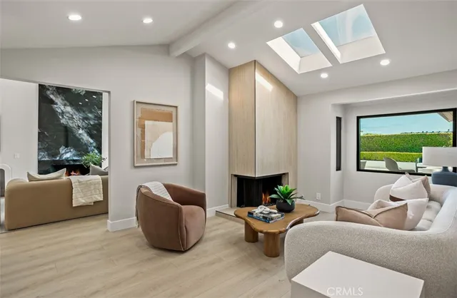 a living room with furniture fireplace and a large window
