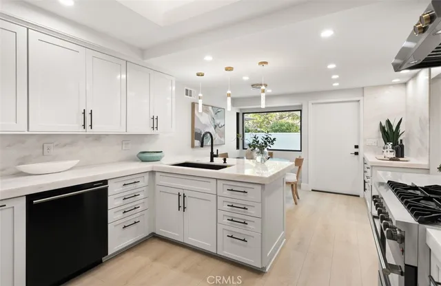 a kitchen with stainless steel appliances kitchen island granite countertop a stove a sink and a refrigerator