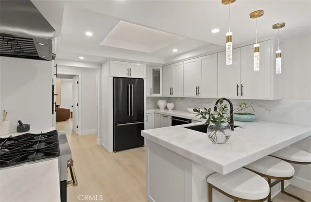 a kitchen with a refrigerator a sink a stove and cabinets
