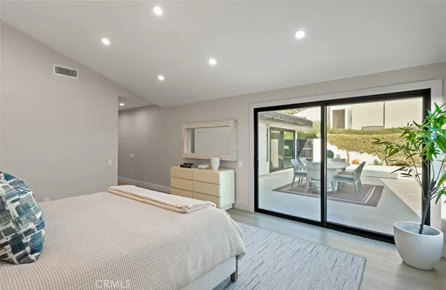 a bedroom with a large bed and a potted plant