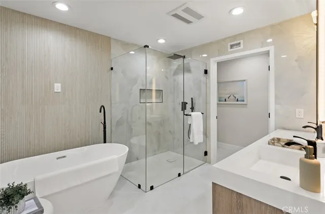 a bathroom with a tub sink toilet and a mirror