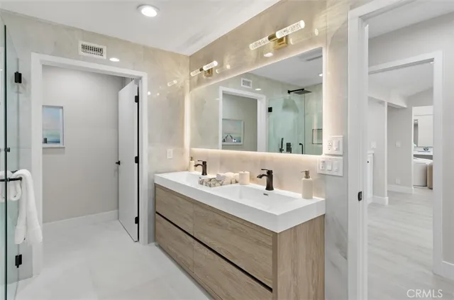 a bathroom with a double vanity sink mirror and shower