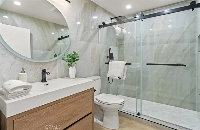 a bathroom with a sink a toilet and shower