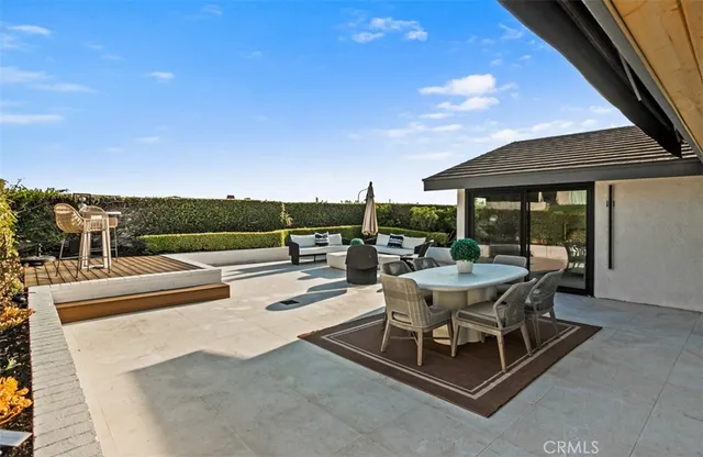 a view of a patio with a table and chairs under an umbrella