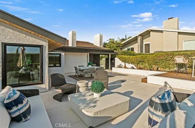 a view of a patio with couches table and chairs with potted plants
