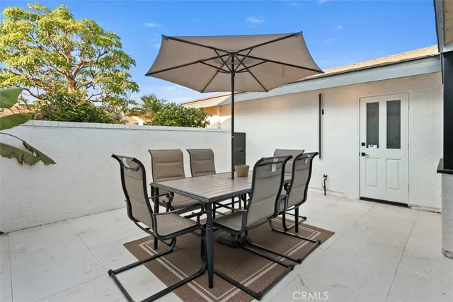 a view of a patio with table and chairs under an umbrella