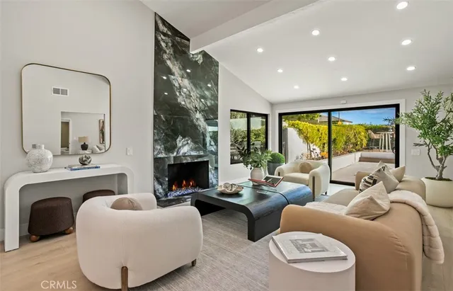a living room with furniture fireplace and a large window
