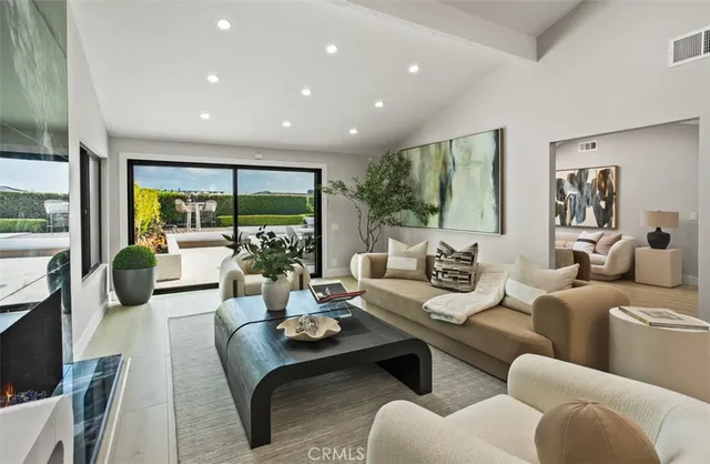 a living room with furniture fireplace and large windows