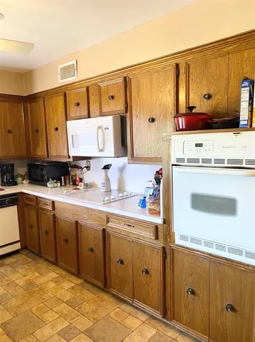 a kitchen with a sink stove and wooden cabinets