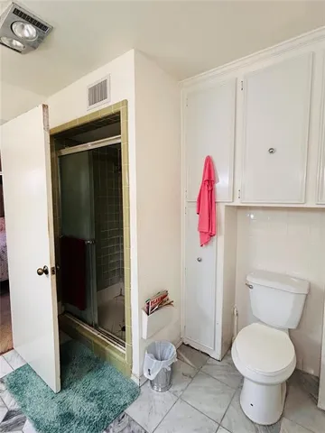 a bathroom with a toilet and a shower