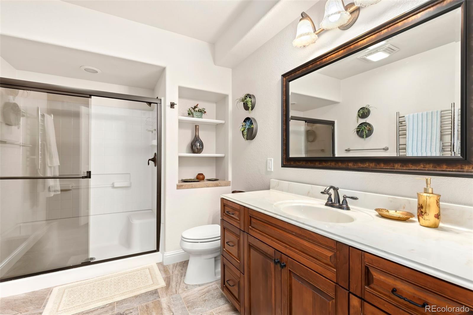 4945 Bierstadt Loop Broomfield, CO 80023 - Photo 25 of 33 a bathroom with a sink a toilet and a large mirror