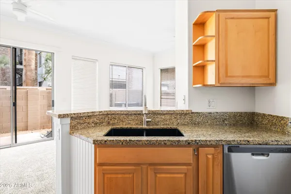 a kitchen with granite countertop a sink and cabinets