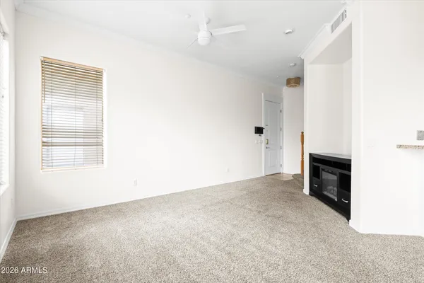 an empty room with fireplace and a window