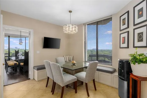 a dining room with furniture potted plants and a flat screen tv