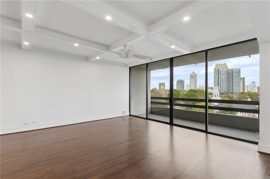 2660 Peachtree Road Northwest, Unit 13F Atlanta, GA 30305 - Photo 13 of 56 a view of an empty room with wooden floor and glass door
