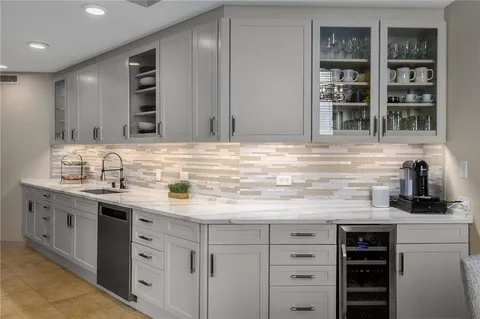 a kitchen with cabinets stainless steel appliances and sink