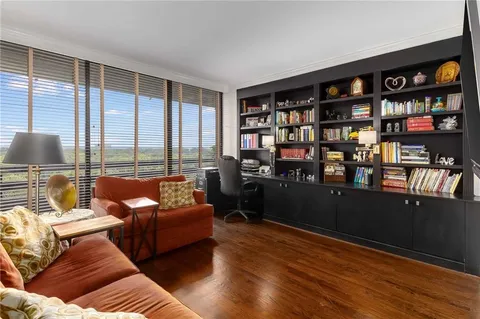 a living room with furniture a bookshelf and a large window