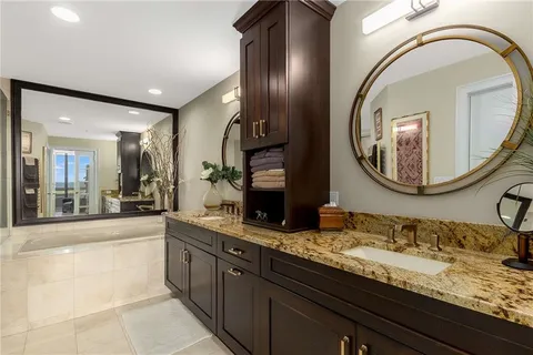 a bathroom with a granite countertop double vanity sinks and a mirror