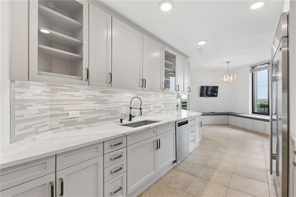 2660 Peachtree Road Northwest, Unit 13F Atlanta, GA 30305 - Photo 25 of 56 a large white kitchen with stainless steel appliances granite countertop a sink and cabinets