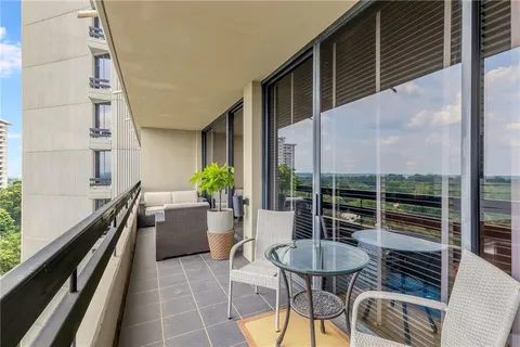 a view of a balcony with chairs and a potted plant