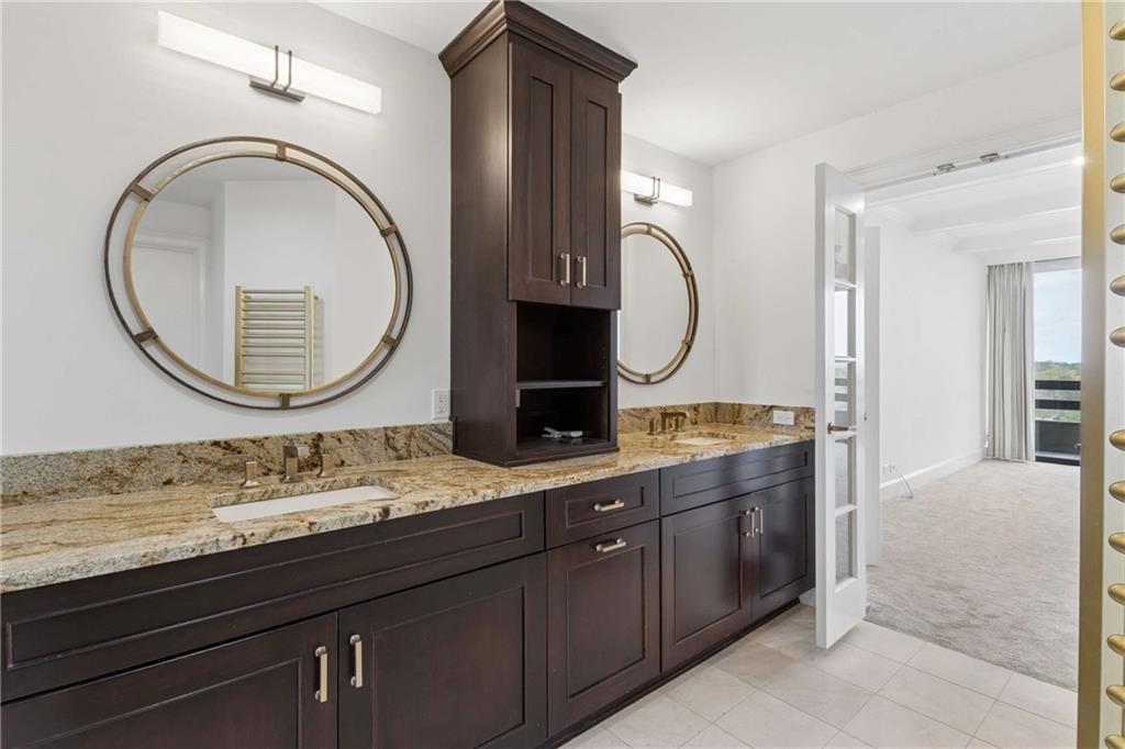 2660 Peachtree Road Northwest, Unit 13F Atlanta, GA 30305 - Photo 33 of 56 a bathroom with a granite countertop double vanity sink and a mirror