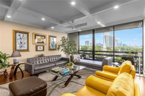a living room with furniture ceiling fan and a large window