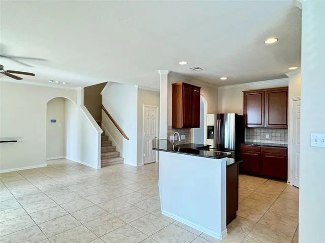 a kitchen with kitchen island granite countertop a sink a counter top space appliances and cabinets