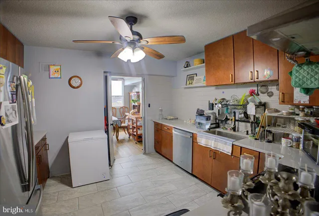 a kitchen with stainless steel appliances granite countertop a sink dishwasher stove and refrigerator