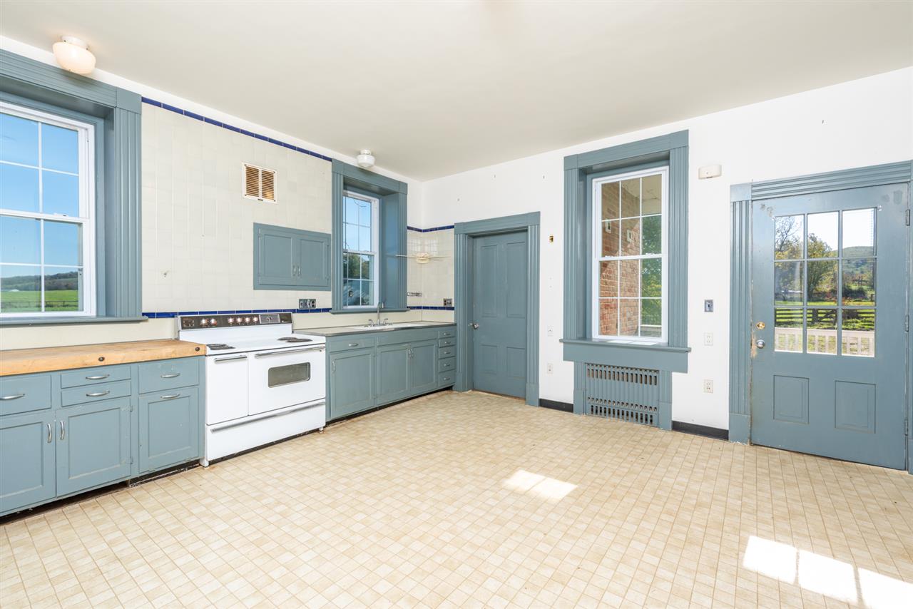 2534 Glebe School Road Swoope, VA 24479 - Photo 12 of 50 a large white kitchen with cabinets a sink a window and a refrigerator