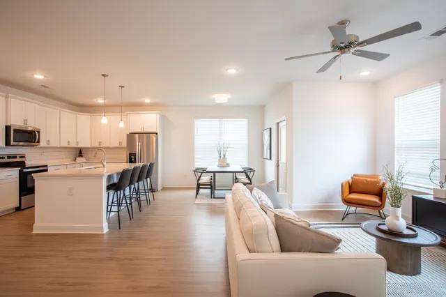 a living room with furniture kitchen and a table