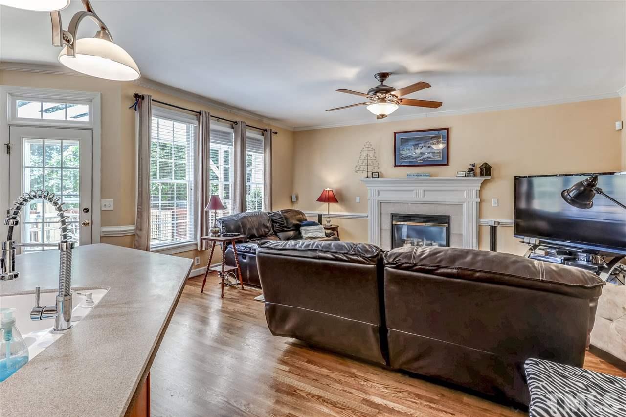 2416 Carruthers Court Raleigh, NC 27615 - Photo 14 of 26 a living room with furniture a flat screen tv and a fireplace