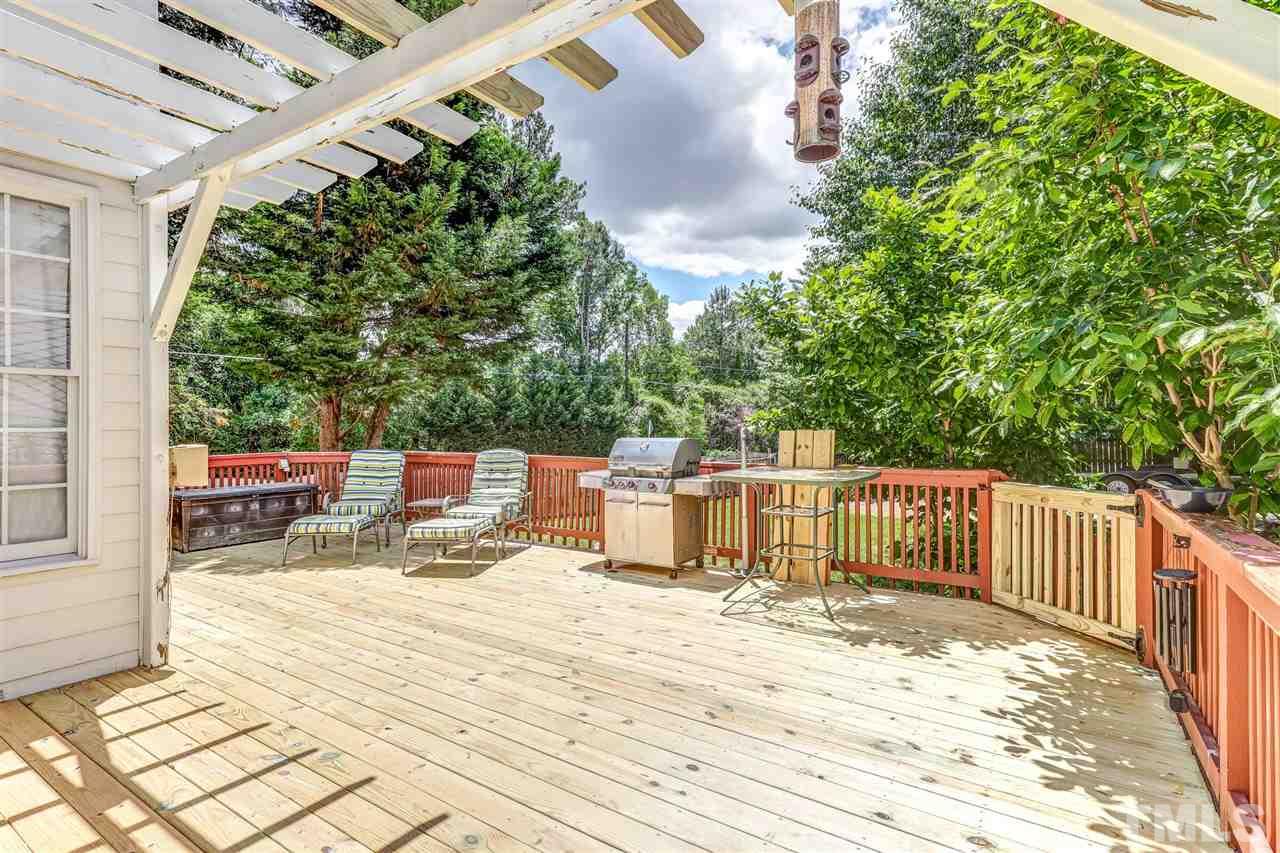 2416 Carruthers Court Raleigh, NC 27615 - Photo 22 of 26 a roof deck with table and chairs and wooden floor