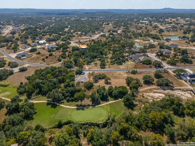 an aerial view of residential house with outdoor space and trees all around